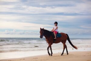 girl horseback riding on beach